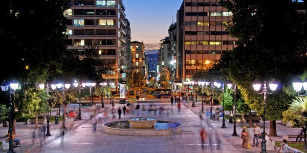 Athens, Greece- October 1, 2007: Night view of the the Syntagma square in the capital city of Greece in Athens with people and tourists walking around.