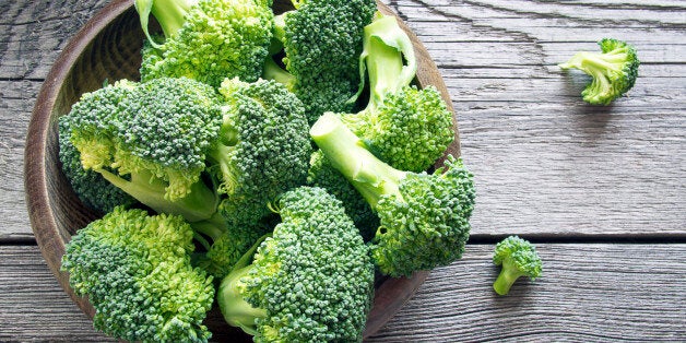 Raw broccoli in a bowl on rustic background