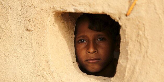 A boy looks from a window of his family's hut at the Shawqaba camp for internally displaced people who were forced to leave their villages by the war in Yemen's northwestern province of Hajjah March 12, 2016. In northwest Yemen, one of the poorest countries in the Middle East, about 400 families uprooted by the war have been stuck in the Shawqaba camp in Hajjah province for the past year. Residents live in poorly built huts that protect them neither from summer heat nor winter cold in a camp that lacks the most basic services. REUTERS/Abduljabbar Zeyad SEARCH