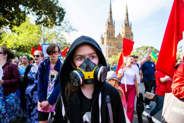 A girl wearing a gas mask marches along College Street during a climate strike rally on September 20, 2019 in Sydney, Australia