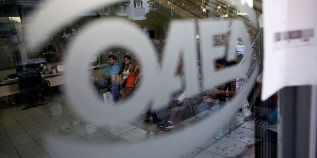 Jobseekers wait inside an OAED employment center in Athens, Greece, on Wednesday, Sept. 10, 2014. Over the past two years, real wages fell in Greece, Portugal, Ireland, Spain and Italy, the OECD said Sept. 3 in a report on employment. Photographer: Kostas Tsironis/Bloomberg via Getty Images