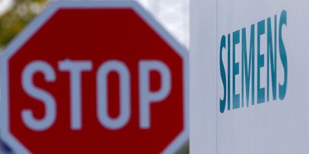Siemens logo is pictured next to a traffic sign 'STOP' in front of the manufacturing plant of Siemens Healthineers in Forchheim near Nuremberg, Germany, October 7, 2016. REUTERS/Michaela Rehle
