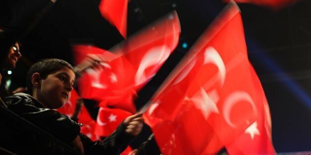 People wave Turkish flags during a campaigning event with the Turkish Prime Minister in Oberhausen, western Germany, on February 18, 2017.Turkish Prime Minister Binali Yildirim speaks to an expected crowd of some 10,000 people of Turkish origin in Germany to promote support for an April 16, 2017 constitutional referendum on expanding President Recep Tayyip Erdogan's powers. / AFP / Sascha Schuermann (Photo credit should read SASCHA SCHUERMANN/AFP/Getty Images)