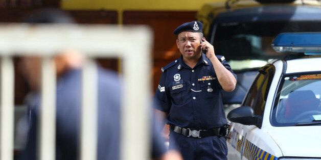 A police officer speaks on his mobile phone at the morgue at Kuala Lumpur General Hospital where Kim Jong Nam's body is held for autopsy in Malaysia, February 19, 2017. REUTERS/Athit Perawongmetha