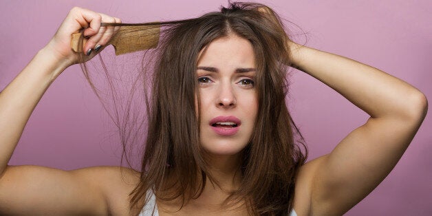 Woman brushing her hair with a wooden comb