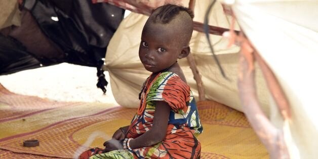 TO GO WITH AFP STORY BY PATRICK FORTA child looks on under a makeshift tent in a camp in the village of Kidjendi near Diffa on June 19, 2016 as displaced families fled from Boko Haram attacks in Bosso. Earlier this month 24 soldiers from Niger and two Nigerian troops were killed in a Boko Haram attack in the Bosso area of Niger, near Lake Chad, prompting Chad to send in reinforcements. / AFP / ISSOUF SANOGO (Photo credit should read ISSOUF SANOGO/AFP/Getty Images)