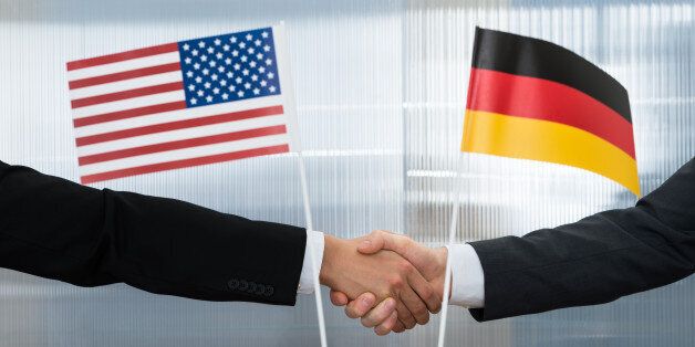 Close-up Of American And German Businessman Shaking Hands In Office