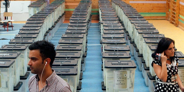 Albanian journalists speak next to ballot boxes in Tirana June 24, 2013. Albania's Socialist opposition urged Prime Minister Sali Berisha to accept defeat on Monday after it took what appeared to be a convincing lead in an election seen as a test of the NATO country's democratic credentials. REUTERS/Arben Celi (ALBANIA - Tags: ELECTIONS POLITICS)