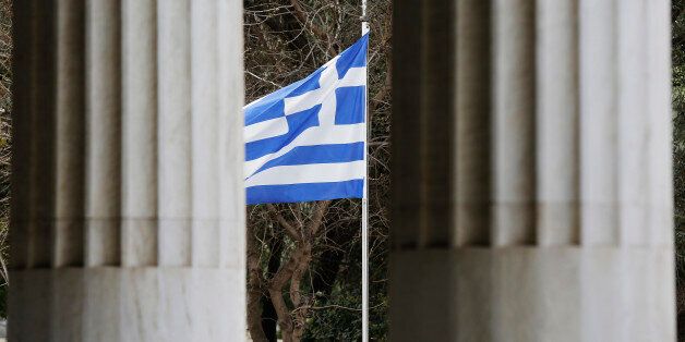 A Greek flag is framed by marble pillars at the Attalos arcade in Athens February 26, 2015. Greece's economy is expected to grow this year but faces risks from the government's ability to fulfill a deal with the euro zone and reform fatigue, central bank governor Yannis Stournaras said in his annual report published on Thursday. The arcade was erected by Attalos II King of Pergamon 159-138 BC and the building was reconstructed by the American school of classical studies in Athens under the auth