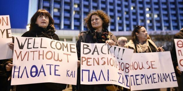 Protesters hold placards forming a text reading 'Dear IMF-EU-ECB commission welcome back! Indeed its so nice to live without pension-job-house' during a protest rally outside the Hilton hotel in Athens where Greek officials hold meetings with the representatives from its creditors on March 1, 2017.Hundreds of pensioners, workers and students demonstrate outside the hotel during a rally organised by a communist - affilited workers union. Greece is back at the negotiating table with the EU and the IMF to secure a deal to keep crucial bailout funds flowing for its crisis-battered economy. / AFP PHOTO / LOUISA GOULIAMAKI (Photo credit should read LOUISA GOULIAMAKI/AFP/Getty Images)