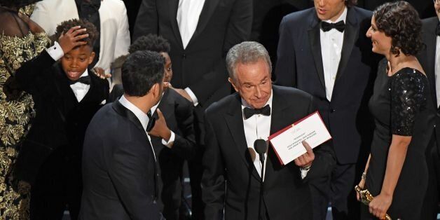 TOPSHOT - The cast of 'Moonlight' and ''La La Land' appear on stage as presenter Warren Beatty (C) shows the winner's envelope for Best Movie 'Moonlight' on stage at the 89th Oscars on February 26, 2017 in Hollywood, California. / AFP / Mark RALSTON (Photo credit should read MARK RALSTON/AFP/Getty Images)