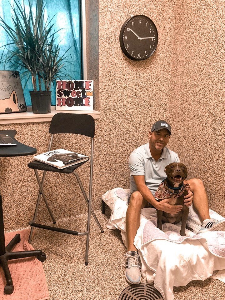 Scott Poore poses with Queen, a 3-year-old terrier mix, in their room at the Great Plains SPCA in Kansas City.