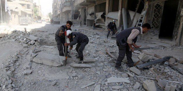 DAMASCUS, SYRIA - OCTOBER 12: Civil defense members carry out search and rescue operation over the wreckage of collapsed buildings after warcrafts belonging to the Assad Regime forces carried out an airstrike over residential areas at opposition controlled Hamuriye town in the Eastern Ghouta region of Damascus, Syria on October 12, 2016. It is reported that dead and wounded after the attack. (Photo by Yusuf Homs/Anadolu Agency/Getty Images)