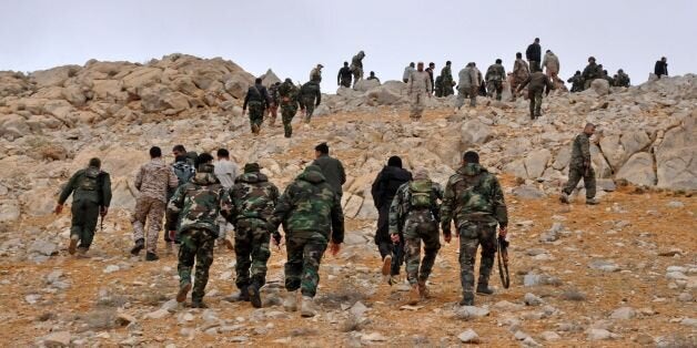 Syrian regime fighters take position as they advance to retake the ancient city of Palmyra, from Islamic State (IS) group fighters on March 2, 2017. / AFP PHOTO / STRINGER (Photo credit should read STRINGER/AFP/Getty Images)