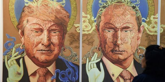 A visitor looks at a painting representing US President Donald Trump (L) and Russian President Vladimir Putin made by Nepalese artist Sunil Sidgel at the India Art Fair in New Delhi on January 2, 2017. / AFP / Dominique FAGET / RESTRICTED TO EDITORIAL USE - MANDATORY MENTION OF THE ARTIST UPON PUBLICATION - TO ILLUSTRATE THE EVENT AS SPECIFIED IN THE CAPTION (Photo credit should read DOMINIQUE FAGET/AFP/Getty Images)