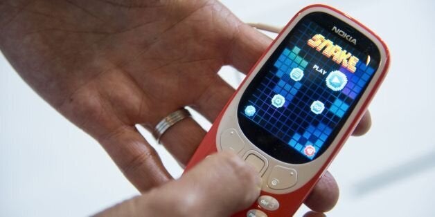 A person plays 'Snake' game on the new 'Nokia 3310' model of Finnish HMD global on the first day of the Mobile World Congress in Barcelonaon on February 27, 2017 in Barcelona.Phone makers will seek to seduce new buyers with artificial intelligence functions and other innovations at the world's biggest mobile fair starting today in Spain. / AFP / Josep Lago (Photo credit should read JOSEP LAGO/AFP/Getty Images)