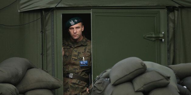 SZCZECIN, POLAND - NOVEMBER 28: A Polish soldier peeks froma tent during the visit of Polish President Andrzej Duda and German President Joachim Gauck at the headquarters of the NATO Multinational Corps Northeast on November 28, 2016 in Szczecin, Poland. Soldiers from 23 NATO countries as well as Sweden and Finland take part in the Corps, which spearheads NATO's Very High Readiness Joint Task Force. (Photo by Sean Gallup/Getty Images)