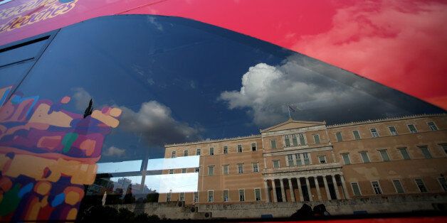 The Greek Parliament reflected on a touristic bus showing the Parthenon in Athens, May 18, 2016 (Photo by Giorgos Georgiou/NurPhoto via Getty Images)