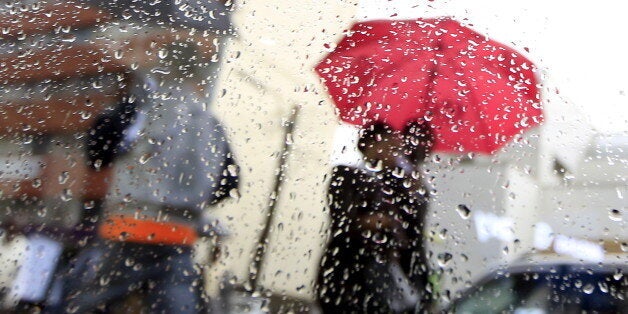 Rain drops are pictured behind a glassy window as people walk home from work during heavy rains in Kenya's capital Nairobi March 9, 2016. REUTERS/Noor Khamis