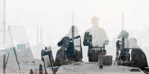 Multiple exposure shot of colleagues in a meeting superimposed over an industrial background