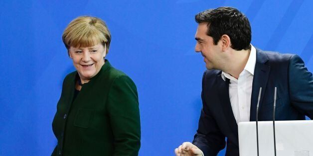 German Chancellor Angela Merkel (L) passes by Greek Prime Minister Alexis Tsipras after delivering a statement ahead talks focused on the refugee crisis, Cyprus, Turkey and Athens' debt woes in Berlin, on December 16, 2016. / AFP / TOBIAS SCHWARZ (Photo credit should read TOBIAS SCHWARZ/AFP/Getty Images)