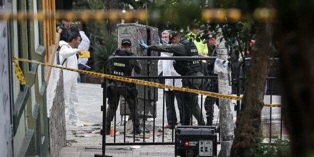 Colombian anti-explosive police inspect the site where a bomb exploded near the La Macarena bullring in downtown Bogota, Colombia, on February 19, 2017. According to official reports, one policeman was killed and 30 people were injured in the explosion. / AFP / STR (Photo credit should read STR/AFP/Getty Images)