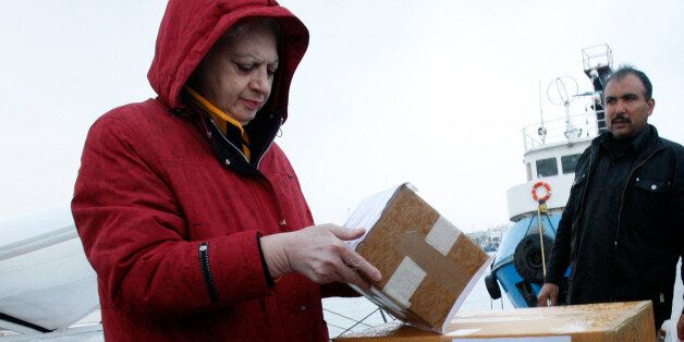 Cypriot Member of Parliament Eleni Theocharous (L) helps load a consignment of medical aid to Gaza on a boat in Larnaca, Cyprus, December 29, 2008. Aid workers, doctors and a former U.S. Congresswoman sailed for battered Gaza with medical aid from Cyprus on Monday, defying Israeli air attacks on the Palestinian territory for the third successive day. REUTERS/Andreas Manolis (CYPRUS)