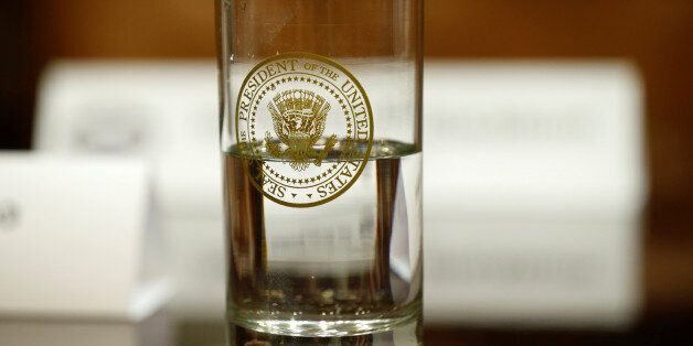 A glass bearing the Presidential seal sits on a table as U.S. President Donald Trump hosts a meeting with House Republicans at the White House in Washington, U.S. February 16, 2017. REUTERS/Kevin Lamarque