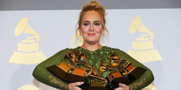 Adele holds the five Grammys she won including Record of the Year for