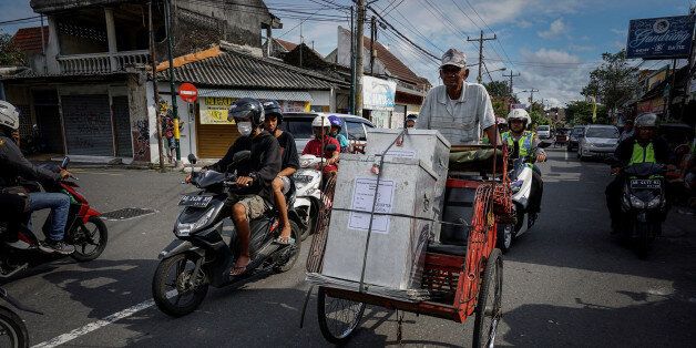 A policeman guards a three wheller as ballot boxes are transported to voting booths in Yogyakarta, Indonesia, February 14, 2017 in this photo taken by Antara Foto. Antara Foto/Hendra Nurdiyansyah/ via REUTERS ATTENTION EDITORS - THIS IMAGE WAS PROVIDED BY A THIRD PARTY. FOR EDITORIAL USE ONLY. MANDATORY CREDIT. INDONESIA OUT.