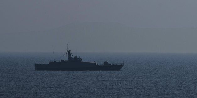 A Turkish warship and a coast guard helicopter patrol the egean sea between Turkish coast and Lesbos island on March 21, 2016 at Kucukkuyu district in Canakkale western Turkey. Greece will not be able to start sending refugees back to Turkey from March 20, 2016, the government said, as the country struggles to implement a key deal aimed at easing Europe's migrant crisis. Under the agreement clinched between Brussels and Anakara last week, migrants who reach the Greek islands will be deported back to Turkey. For every Syrian returned, the EU will resettle one from a Turkish refugee camp. / AFP / OZAN KOSE (Photo credit should read OZAN KOSE/AFP/Getty Images)