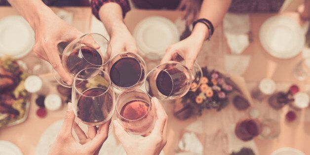 Friend clinking glasses above dinner table