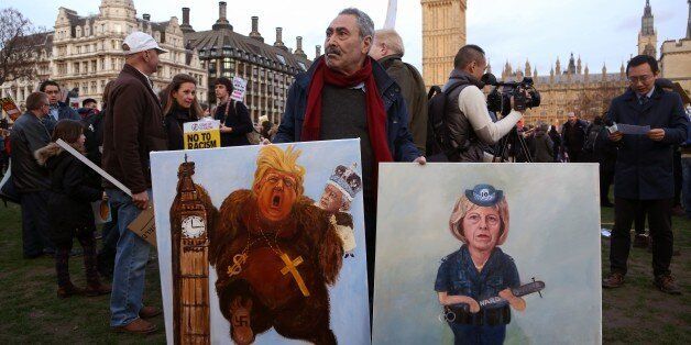 LONDON, UNITED KINGDOM - FEBRUARY 20: People hold banners as they gather to protest against President Trump after British Prime Minister Theresa May transmitted Elizabeth II's invitation to Trump at Parliament Square in London, United Kingdom on February 20, 2017. (Photo by Tayfun Salci/Anadolu Agency/Getty Images)