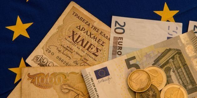 A picture taken on June 29, 2015 in Lille shows Drachma bills, Greece's former currency, next to euro bills and coins. The European single currency briefly dropped below $1.1 today as investors grow concerned Greece is headed for a debt default and a possible eurozone exit. AFP PHOTO / DENIS CHARLET (Photo credit should read DENIS CHARLET/AFP/Getty Images)