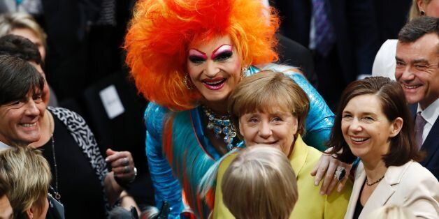 German drag Queen Olivia Jones (C) lays her hand on the shoulder of German Chancellor Angela Merkel (C, lower) as the head coach of Germany's football team Joachim Loew (L) watches ahead of the presidential election at the Bundesversammlung federal assembly Bundestag (lower house of parliament)on February 12, 2017 in Berlin.The German President is not chosen by popular vote but is elected by a special assembly of MPs and public figures. / AFP / Odd ANDERSEN (Photo credit should read ODD ANDERSEN/AFP/Getty Images)