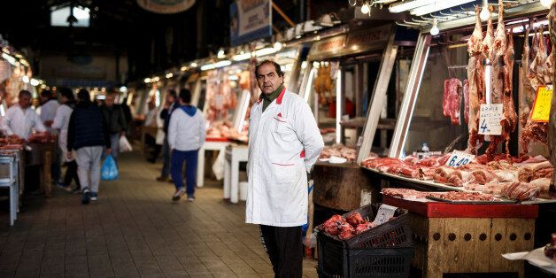 A butcher waits for clients inside the main meat market of Athens, Greece, February 17, 2017. REUTERS/Alkis Konstantinidis SEARCH