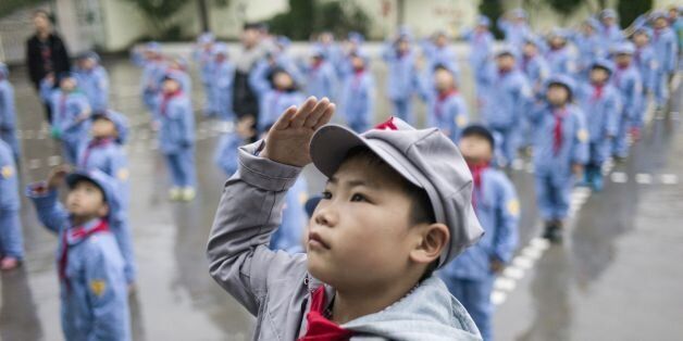 TOPSHOT - This photo taken on November 7, 2016 shows students attending the flag-raising ceremony at the Yang Dezhi 'Red Army' elementary school in Wenshui, Xishui country in Guizhou province. In 2008, Yang Dezhi was designated a 'Red Army primary school' -- funded by China's 'red nobility' of revolution-era Communist commanders and their families one of many such institutions that have been established across the country. Such schools are an extreme example of the 'patriotic education' which China's ruling Communist party promotes to boost its legitimacy -- but which critics condemn as little more than brainwashing. / AFP / Fred DUFOUR (Photo credit should read FRED DUFOUR/AFP/Getty Images)