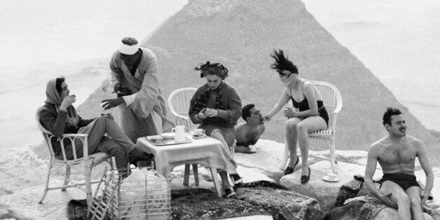 Tourists sunbathe and take tea at the top of the Great Pyramid.