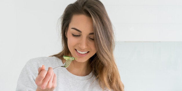 Healthy young woman dieting and eating a salad at home