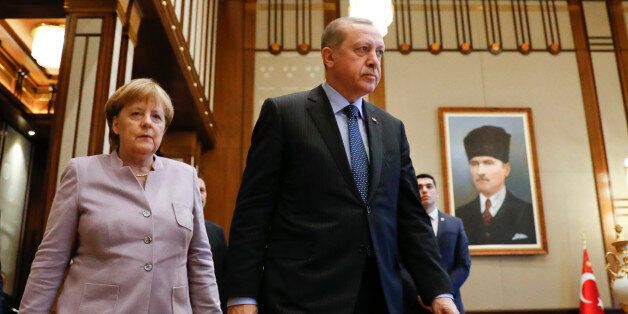 Refile with corrected typo - Turkish President Recep Tayyip Erdogan and German Chancellor Angela Merkel walk past a picture of Turkish Republic state founder Kemal Ataturk before their bilateral meeting at the presidential palace during the first visit since July's failed coup in Ankara, Turkey, February 2, 2017. REUTERS/Umit Bektas TPX IMAGES OF THE DAY