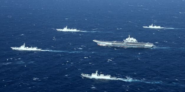 This aerial photo taken on January 2, 2017 shows a Chinese navy formation, including the aircraft carrier Liaoning (C), during military drills in the South China Sea.The aircraft carrier is one of the latest steps in the years-long build-up of China's military, as Beijing seeks greater global power to match its economic might and asserts itself more aggressively in its own backyard. / AFP / STR / China OUT (Photo credit should read STR/AFP/Getty Images)