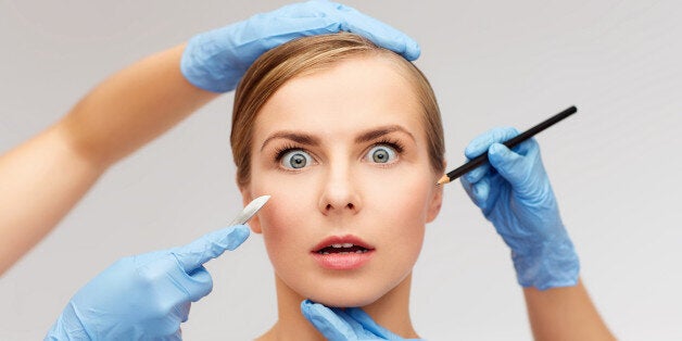 healthcare, beauty and medicine concept - beautiful woman face and beautician hands with pencil and scalpel