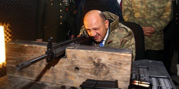 KIRIKKALE, TURKEY - JANUARY 11: Turkish National Defense Minister Fikri Isik (C) performs a test-fire with MPT-76 National Infantry Rifle during the delivery ceremony in Kirikkale, Turkey on January 11, 2017. (Photo by Evrim Aydin/Anadolu Agency/Getty Images)
