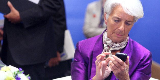 Christine Lagarde, managing director of the International Monetary Fund (IMF), uses her smartphone before the International Monetary and Financial Committee (IMFC) meeting at the Annual Meetings of the IMF and the World Bank Group in Tokyo, Japan, on Saturday, Oct. 13, 2012. The world's finance ministers and central bank governors are gathered in Tokyo for the annual meetings of the IMF and the World Bank as the rebound from the deepest global recession since World War II stagnates. Photographer: Tomohiro Ohsumi/Bloomberg via Getty Images