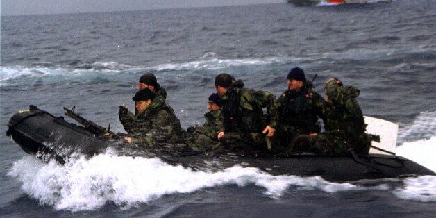 Turkish commandos return after landing on the disputed island of Imia/Kardak after Greece withdrew from the island January 31. Greece and Turkey began to withdraw their naval units from around a disputed island in the eastern Aegean at 6:00 a.m. local time, Greek Foreign Minister Theodoros Pangalos and Defence Minister Gerassimos Arsenis announced today. At right is a Turkish Coast Guard vessel
