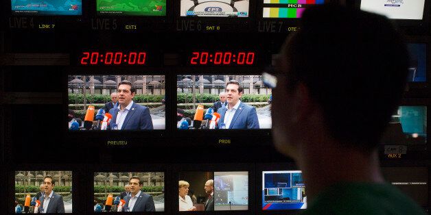 Alexis Tsipras, Greece's prime minister, center, is seen on television monitors in the television production gallery as he arrives in Brussels, ahead of a news broadcast by Skai Television, operated by the Skai Group, in Piraeus, Greece, on Sunday, July 12, 2015. Tsipras was given three days to push new austerity measures through parliament and keep alive Greece's chances of staying in the euro. Photographer: Simon Dawson/Bloomberg via Getty Images