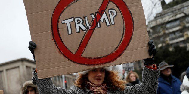 TOPSHOT - An anti-Trump protester holds a sign during a demonstration in Paris, on February 4, 2017.US President Donald Trump lashed out on February 4, 2017 at a court ruling suspending his controversial ban on travelers from seven Muslim countries, dismissing it as 'ridiculous' and vowing to get it overturned. The order blocking the ban, issued late on February 3, 2017 by Seattle US District Judge James Robart, is valid across the United States, pending a full review of a complaint filed by Washington state's attorney general. / AFP / THOMAS SAMSON (Photo credit should read THOMAS SAMSON/AFP/Getty Images)