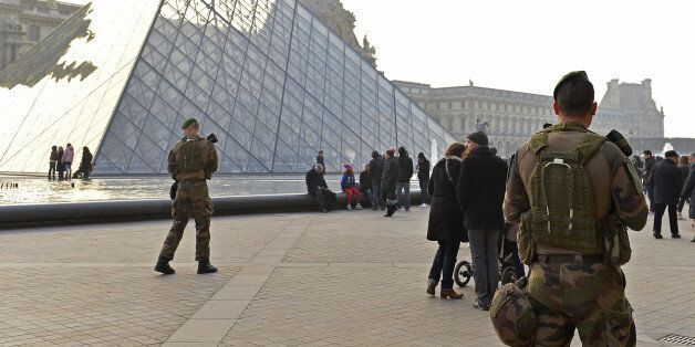 PARIS, FRANCE - DECEMBER 30: French military officers stand guard outside the Louvre as French Minister of Defence Jean Yves Le Drian and French Minister of Interior Bruno Le Roux, visit the French armed forces and Police forces before the New Year's Eve celebrations at the Louvre on December 30, 2016 in Paris, France. Due to terrorism fears, over 100,000 police officers will be mobilized all over France, with around 11,000 deployed in Paris, for the New Year celebrations. (Photo by Aurelien Meunier/Getty Images)
