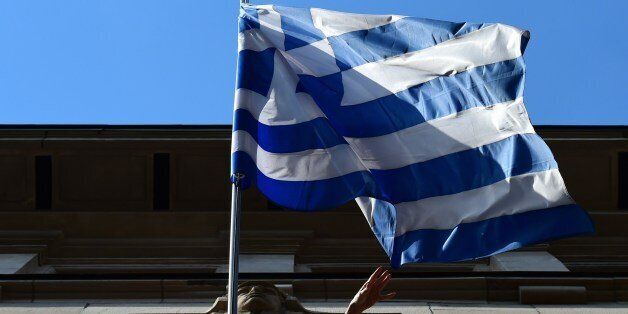 The Greek national flag is on display outside the Embassy of Greece to Germany on June 29, 2015 in Berlin. After talks between Athens and its creditors broke down, leaving Greece headed for an EU-IMF default and possible exit from the eurozone, the ECB said on June 28, 2015 it would keep open Emergency Liquidity Assistance (ELA) to the debt-hit country's banks. AFP PHOTO / JOHN MACDOUGALL (Photo credit should read JOHN MACDOUGALL/AFP/Getty Images)