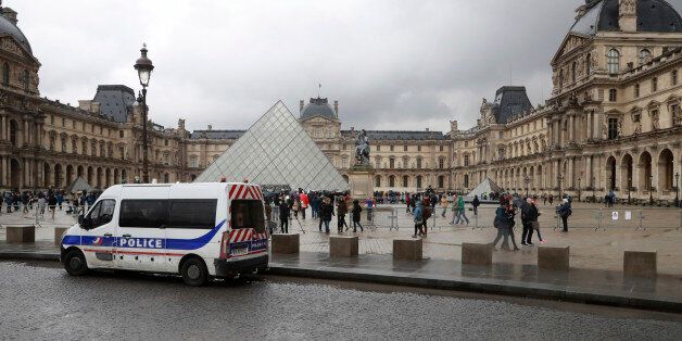 People walk past a police vehicle parked in front of the Louvre Pyramid in Paris on February 4, 2017 a day after a machete-wielding attacker lunged at four French soldiers while shouting 'Allahu Akbar' ('God is greatest') in a public area that leads to one of the Louvre Museum's entrances.The condition of a man who was shot after attacking troops at the Louvre in Paris has improved and is 'no longer life-threatening', a source close to the case said on February 4, 2017. But the man has not recovered sufficiently to be able to communicate with investigators, the source said. / AFP / JACQUES DEMARTHON (Photo credit should read JACQUES DEMARTHON/AFP/Getty Images)